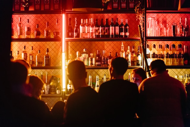 dimly lit bar front with a crowd of people