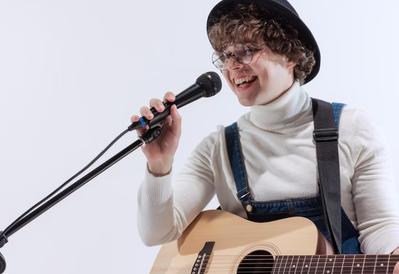 person with a guitar next to a microphone